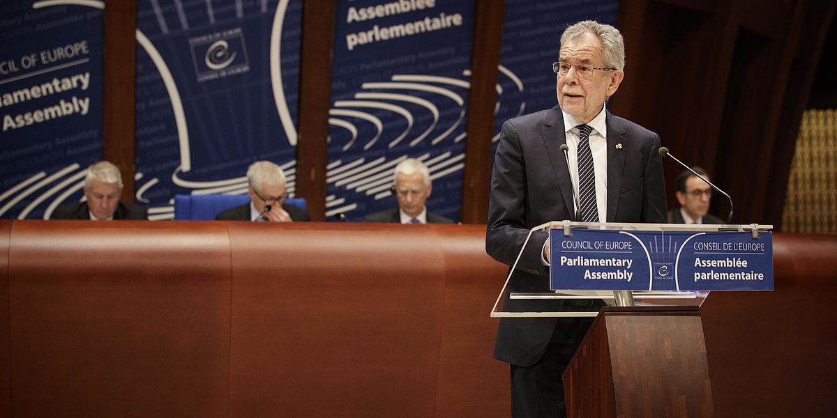 Alexander Van der Bellen steht an einem Rednerpult